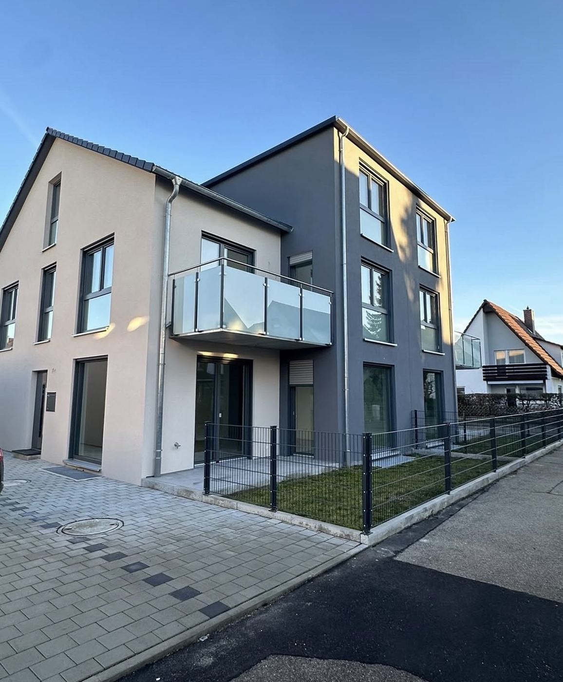 Mehrfamilienhaus: Fassade in zwei Farbtönen, sauber getrennt an Kanten und Laibungen.